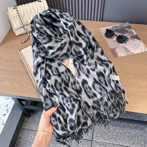 Fashionable leopard print long scarf with tassels on a rustic wooden background