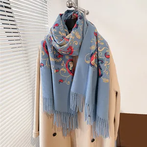 Dettaglio della sciarpa grigio-blu effetto cashmere con ricami paisley e frange lunghe