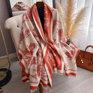 Détail d'un châle d'hiver doux avec motif Toile de Jouy rouge et bords à franges