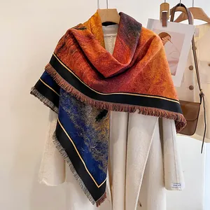 Detailed close-up of gradient orange and blue cashmere shawl with fringe and piped edges