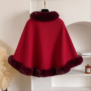 Detail of dark red winter cape with plush faux fur collar and textured wave knit fabric
