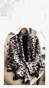 Detail view of leopard print long silk scarf with elegant black piping on soft fabric