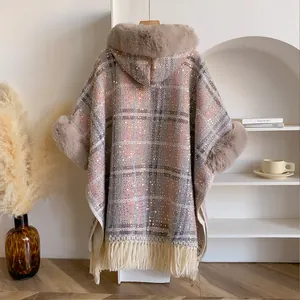 Détail du poncho à carreaux avec col en fausse fourrure, paillettes et franges