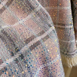 Détail de tissu à carreaux rose et gris avec des paillettes et des franges blanches