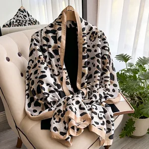 Close-up of leopard print silk scarf with luxury champagne satin borders and soft texture