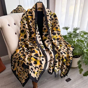 Detail of elegant leopard print silk scarf with black borders draped over a chair