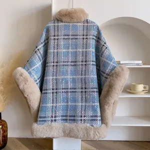 Détail d'un poncho à carreaux bleu clair avec col en fausse fourrure épaisse et paillettes