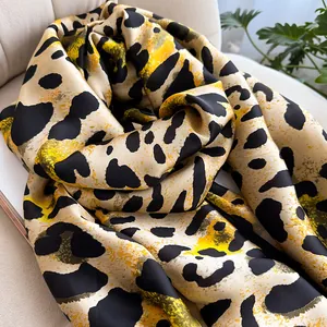 Close-up of leopard print faux silk scarf showing smooth satin texture and elegant drape
