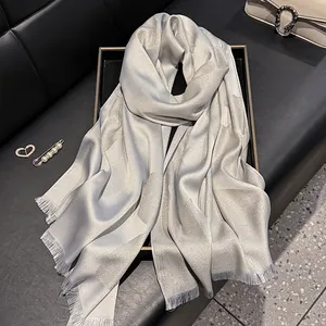 Detail of silver-grey silk scarf featuring shimmering metallic glitter and fringe edges