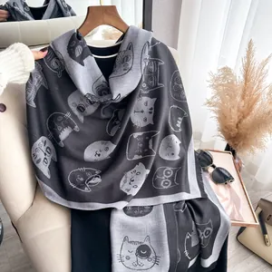 Reversible cute cat print scarf for women with tassels in grey tones on a chair