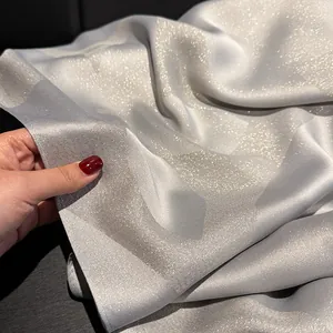 Close-up of elegant silver-grey silk shawl with metallic shimmering thread details