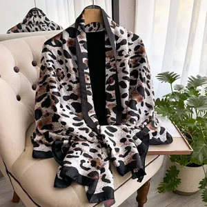 Elegant leopard print leopard silk scarf lightweight shawl draped on a modern beige sofa