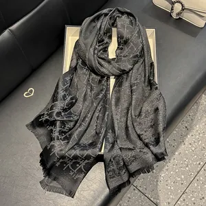 Detailed view of dark grey silk scarf with elegant letter jacquard and subtle shimmer