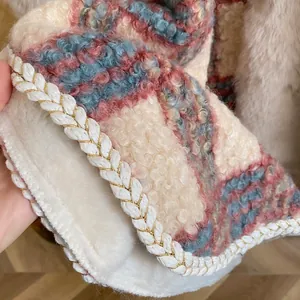 Detail eines rosa karierten Kapuzenponchos mit weichem Sherpa-Futter und Zierrand