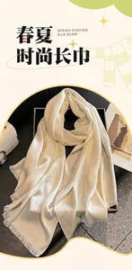 Close-up of white silk scarf with jacquard rose patterns and elegant fringe detail