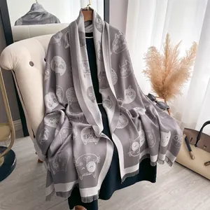 Close-up of cute cartoon cat jacquard pattern and fringe edge on gray cotton shawl