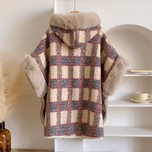 Nahaufnahme von Kapuzenponcho mit Vintage-Karomuster und flauschigem Kunstpelzbesatz