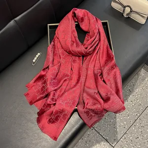 Macro shot of dark red silk scarf showing Dior-style jacquard and fringe details
