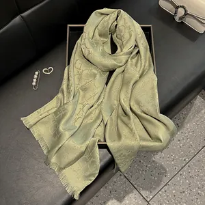 Detail of light green jacquard silk scarf with fine fringe and elegant pattern texture