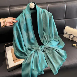 Detailed view of teal pashmina shawl featuring shimmering metallic wavy woven patterns