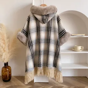 Nahaufnahme des karierten Kapuzenponchos mit Kunstpelzbesatz und eleganten Quasten