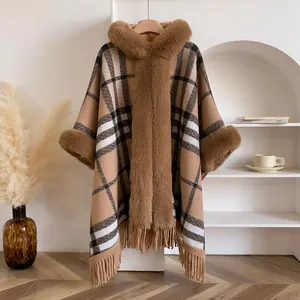 Detailansicht des Winter-Ponchos mit klassischem Karomuster und Kunstpelzbesatz
