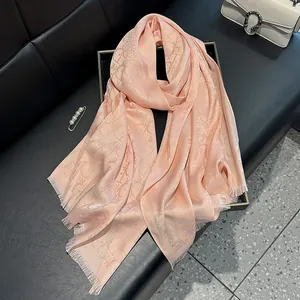 Elegant peach silk scarf with lettered monogram patterns and fine fringe edges