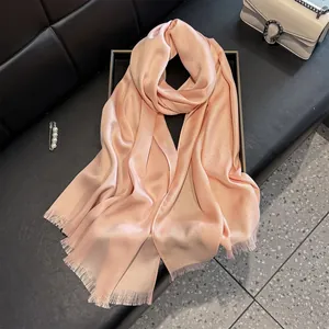 Close-up of pink silk-like scarf with subtle metallic glitter and short fringe edge