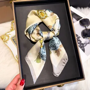 Detail of silk-feel scarf with blue roses and gold chain patterns on display