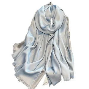 Elegant light blue silk shawl with interlocking CD monogram pattern and fringe edges