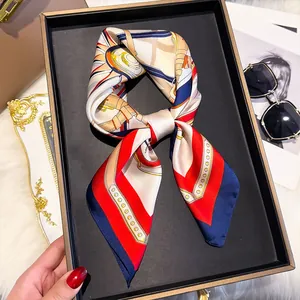 Detail of silk square scarf tied in a bow with equestrian print on a display tray