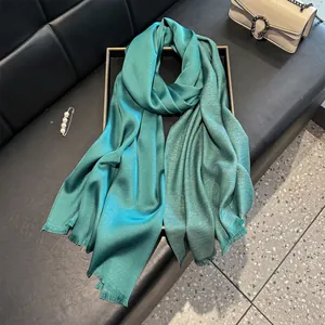 Detailed macro view of teal silk scarf with silver glitter threads and fringe trim
