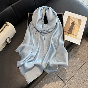 Close-up of light blue silk scarf featuring camellia jacquard and frayed edge details