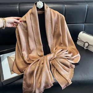 Detailed view of champagne silk scarf with butterfly jacquard and fine tassel edges