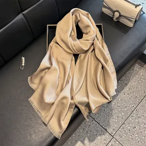 Detail of champagne gold silk scarf with metallic shimmer and elegant fringe edges