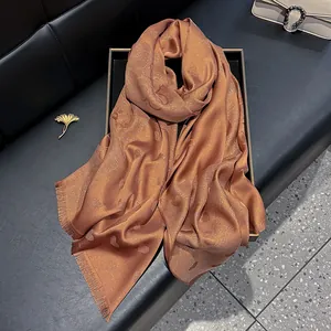 Detailansicht der bronzefarbenen Seidenschal mit Glitzer-Herz-Jacquard und Quastensaum