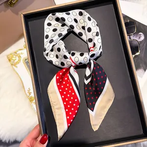 Close-up of silk square scarf featuring vibrant red and black polka dot pattern details