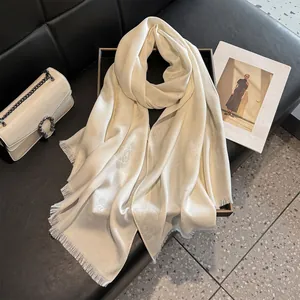 Detail of cream silk scarf with floral jacquard texture and short fringed edges