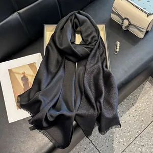 Detail of black silk scarf with silver shimmer texture and elegant fringe edges