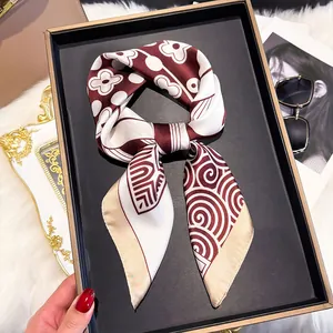 Detail of silk square scarf in burgundy and beige with elegant floral patterns