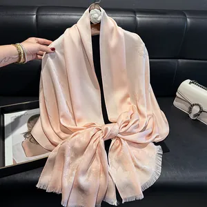 Pink silk-touch scarf with butterfly jacquard and fringe, shown in elegant scene