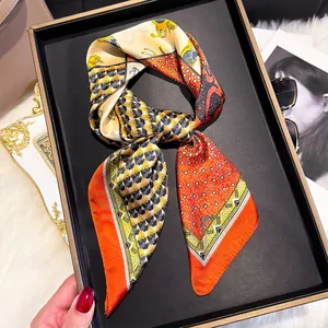 Close-up of elegant silk twilly with horse patterns and polka dots in a luxury gift box