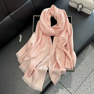 Elegant pink jacquard silk scarf with floral patterns and delicate fringed edges
