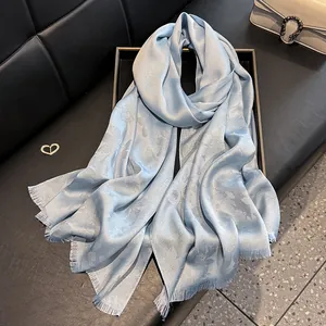 Light blue floral silk scarf with elegant tassels and shimmering silver thread details