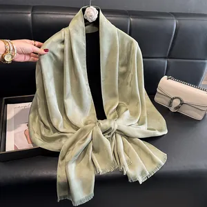 Detalle del pañuelo de seda verde claro con delicada textura floral de jacquard y bordes lisos