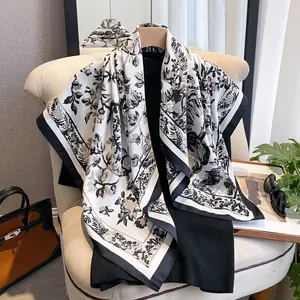 Detail of silk-like scarf with black and white vintage floral print and striped border