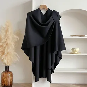 Detail of black knitted shawl featuring a stylish shoulder bow and elegant drape design