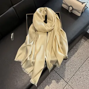Macro detail of champagne gold silk scarf with shimmering finish and fringe edges