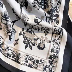 Close-up of vintage floral print silk scarf showing soft texture and black border