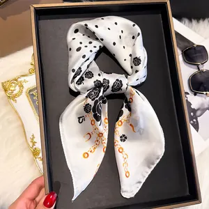 Detail of silk square scarf featuring black polka dots and rose prints on plush background